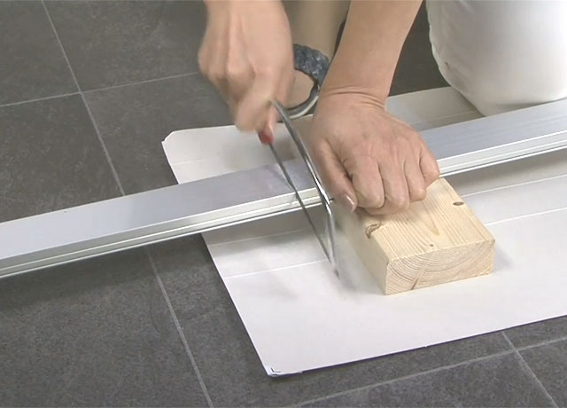 手ノコで切っていくアルミ材のアミド枠